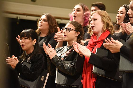 波胆网站音乐学院的学生们站在唱诗班的立管上，一边听着音乐，一边穿着黑色的衣服. 